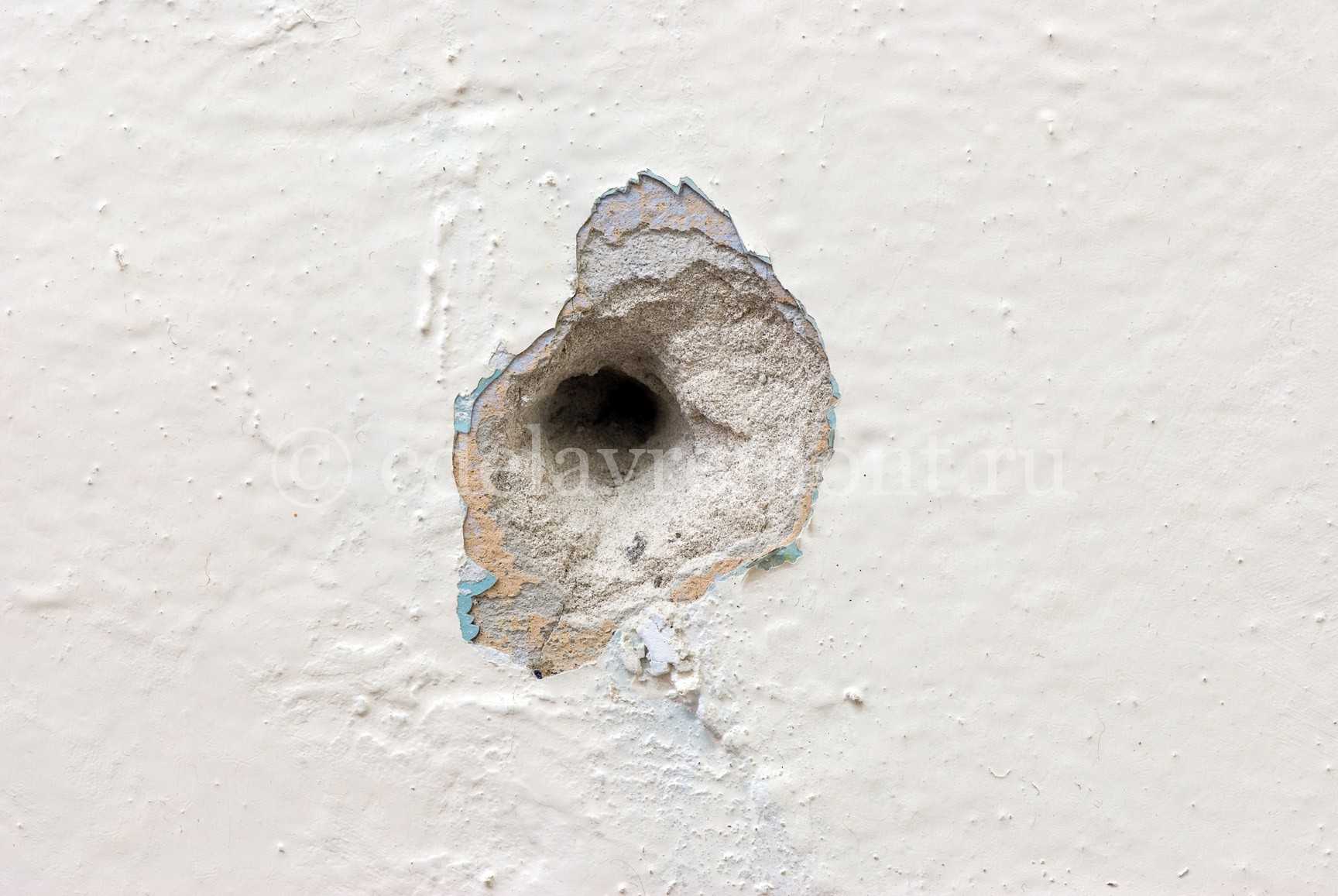 С помощью маленького отверстия. Дырка в стене. Стена с пулевыми отверстиями. Пулевое отверстие в бетоне. Дыра в бетонной стене.